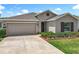 Charming single-story home featuring a well-manicured lawn and a two-car garage with neutral stucco exterior at 6946 Perch Hammock Loop, Groveland, FL 34736