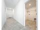 Hallway leading to a laundry room with neutral tile floors at 6946 Perch Hammock Loop, Groveland, FL 34736