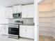 Updated kitchen features white cabinets, stainless steel appliances, and a walk-in pantry at 6946 Perch Hammock Loop, Groveland, FL 34736