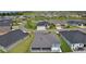 An aerial view shows the home is part of a neighborhood featuring a large pond and verdant landscaping at 6949 Minchew Cir, The Villages, FL 34762