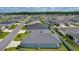 Aerial neighborhood view: a home situated among many similar homes with lush green lawns at 6949 Minchew Cir, The Villages, FL 34762