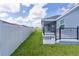 Backyard patio featuring black metal railing and a screened in lanai with white vinyl fence at 6949 Minchew Cir, The Villages, FL 34762