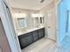 Modern bathroom featuring a double vanity with gray cabinets and a gray wood-look tile floor at 6949 Minchew Cir, The Villages, FL 34762