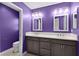 Bathroom with double vanity, large mirrors, under-sink cabinets, and an adjacent toilet at 6949 Minchew Cir, The Villages, FL 34762