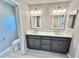 Bathroom with a gray vanity with double sinks and a white quartz countertop, and gray vinyl plank floors at 6949 Minchew Cir, The Villages, FL 34762