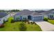 Inviting single-story home featuring verdant landscaping, healthy lawn and an attached two-car garage at 6949 Minchew Cir, The Villages, FL 34762
