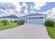 Charming single Gathering home with lush green lawn, mature plantings, and long driveway leading to two car garage at 6949 Minchew Cir, The Villages, FL 34762