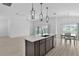 Bright kitchen featuring an island with a sink and a view of the dining and living areas at 6949 Minchew Cir, The Villages, FL 34762
