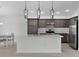 Modern kitchen with stainless steel appliances and a large island with seating space at 6949 Minchew Cir, The Villages, FL 34762