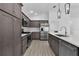 Modern kitchen with stainless steel appliances, quartz countertops and dark brown cabinetry at 6949 Minchew Cir, The Villages, FL 34762