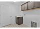 Functional laundry room with gray cabinets, a sink, and a white door at 6949 Minchew Cir, The Villages, FL 34762