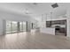 Bright living room with sliding glass doors, ceiling fan and open view to the kitchen at 6949 Minchew Cir, The Villages, FL 34762