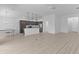 Open floor plan with kitchen, dining and living areas with light-colored floors at 6949 Minchew Cir, The Villages, FL 34762