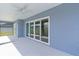 View of covered outdoor patio and backyard with large glass sliding doors at 6949 Minchew Cir, The Villages, FL 34762