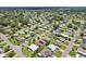 A high-angle view of a cozy residential area featuring neatly arranged houses, mature landscaping, and a serene pond at 703 Royal Palm Ave, Lady Lake, FL 32159