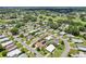 Expansive aerial view of a vibrant residential community with well-manicured lawns, lush trees, and a nearby golf course at 703 Royal Palm Ave, Lady Lake, FL 32159