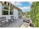Outdoor patio with seating and awning, offering a relaxing space with privacy hedge at 703 Royal Palm Ave, Lady Lake, FL 32159