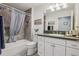 Well-lit bathroom featuring a tub with shower and vanity sink at 703 Royal Palm Ave, Lady Lake, FL 32159