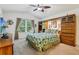 Relaxing bedroom with a ceiling fan and large window that invites the natural light at 703 Royal Palm Ave, Lady Lake, FL 32159