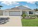 Charming single story home with a three car garage, well-manicured lawn, and mature plantings at 703 Royal Palm Ave, Lady Lake, FL 32159