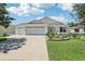 Charming home exterior with well-manicured lawn and three-car garage at 703 Royal Palm Ave, Lady Lake, FL 32159