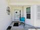 Inviting front porch area with a comfortable chair and decorative accents at 703 Royal Palm Ave, Lady Lake, FL 32159