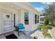 Inviting front porch with chair, decorative rocks, and potted plants at 703 Royal Palm Ave, Lady Lake, FL 32159