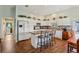 Bright kitchen features an island with seating and white cabinets with modern appliances at 703 Royal Palm Ave, Lady Lake, FL 32159