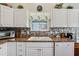 Kitchen showcasing white cabinets, modern backsplash, and stainless steel appliances at 703 Royal Palm Ave, Lady Lake, FL 32159