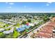 A quaint home with a blue roof is surrounded by well-kept landscaping within a peaceful, tree-filled neighborhood at 714 Prado Dr, The Villages, FL 32159
