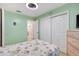 Cozy bedroom with closet, doorway to the bathroom, wood laminate flooring, and green walls at 714 Prado Dr, The Villages, FL 32159