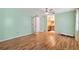 Airy bedroom with wood floors, pale green walls, and a view into an en-suite bathroom through French doors at 714 Prado Dr, The Villages, FL 32159