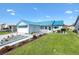 Cozy home with blue roof and awnings, showcasing landscaped front yard and spacious driveway at 714 Prado Dr, The Villages, FL 32159