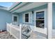 Close-up of the charming front porch with seating, picket fence, and stylish exterior details at 714 Prado Dr, The Villages, FL 32159