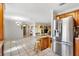 Open-concept kitchen with stainless steel refrigerator, eat-in island, and bright, tiled flooring at 714 Prado Dr, The Villages, FL 32159
