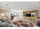 Spacious living room featuring tile flooring, built-in entertainment center, and open access to dining area at 714 Prado Dr, The Villages, FL 32159