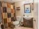 Bathroom featuring a shower, toilet, and sink with decorative mirror at 7211 Se 120Th St, Belleview, FL 34420