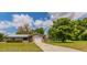 Single-story home with an attached garage, long driveway, and a spacious front yard with mature trees at 7211 Se 120Th St, Belleview, FL 34420