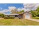 Single-story home showcasing a garage and a metal roof, complemented by a lush green lawn at 7211 Se 120Th St, Belleview, FL 34420