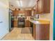 Functional kitchen featuring wooden cabinets, a black appliance suite, and durable tile flooring at 7211 Se 120Th St, Belleview, FL 34420