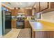 Functional kitchen with wooden cabinets, a black appliance suite, and tile flooring at 7211 Se 120Th St, Belleview, FL 34420