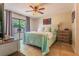 Spacious main bedroom with tile flooring, ceiling fan and sliding glass door to lanai at 7211 Se 120Th St, Belleview, FL 34420