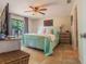 Spacious main bedroom with tile flooring, ceiling fan and sliding glass door to lanai at 7211 Se 120Th St, Belleview, FL 34420