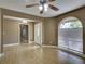 Open-concept living room featuring a ceiling fan and a large arched window with natural light at 728 Silversmith Cir, Lake Mary, FL 32746