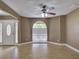 Bright living room with light wood floors, a large window, and a ceiling fan, offering a cozy atmosphere at 728 Silversmith Cir, Lake Mary, FL 32746