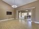 Open living room with sliding glass doors, high ceilings, and a mounted television at 728 Silversmith Cir, Lake Mary, FL 32746