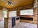 Outdoor kitchen featuring stone walls, a mini-fridge, granite countertops, and a ceiling fan for comfort at 728 Silversmith Cir, Lake Mary, FL 32746