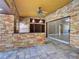 Covered patio with stone accents, ceiling fan, bar seating, and access to the interior, perfect for entertaining at 728 Silversmith Cir, Lake Mary, FL 32746