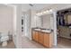 Bright bathroom featuring a double sink vanity, neutral tile flooring, and a large mirror with vanity lighting at 7901 Iceland Gull St, Winter Garden, FL 34787