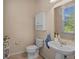 Cozy half-bathroom featuring a modern sink, cabinet, and a large bright window at 7901 Iceland Gull St, Winter Garden, FL 34787
